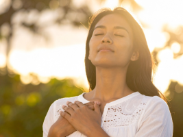Entspannte Frau, die sich die Hände an die Brust legt
